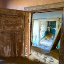 Kolmanskop – německé město duchů uprostřed namibijské pouště - Kolmanskop-through-the-door-frames