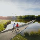 Cyklostezka vedoucí pod hladinou belgického rybníka - fietsen-door-het-water-in-bokrijk